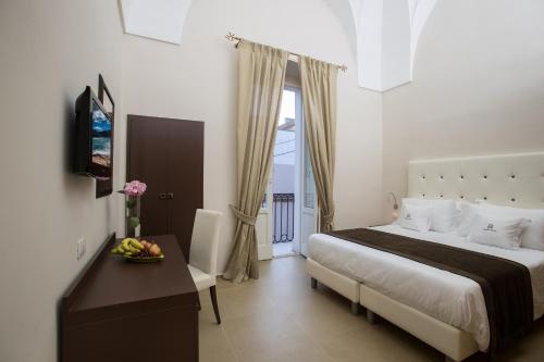 ein Schlafzimmer mit einem Bett und einem Tisch mit einer Schale Obst in der Unterkunft Palazzo Perla - Rooms and Suite in Gallipoli