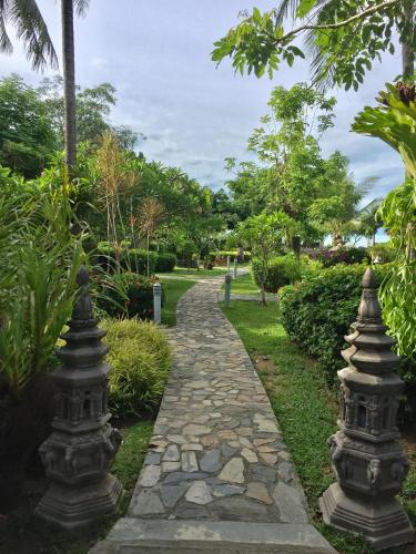 a stone path through a park with trees at Baan Laem Noi Villa's in Mae Nam