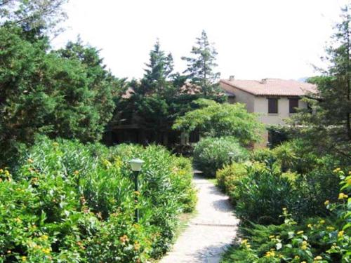 un jardin avec un chemin menant à une maison dans l'établissement Appartamento Porto Rotondo, à Porto Rotondo