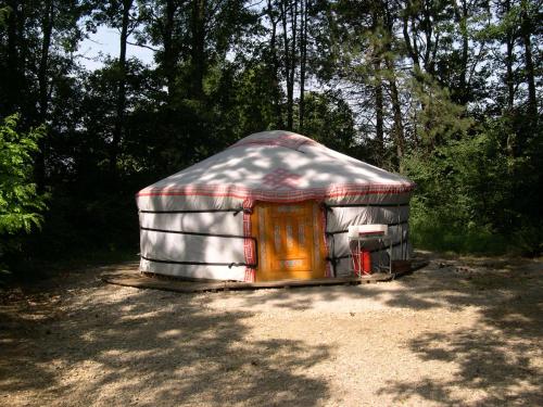 a yurt is sitting in the middle of a forest at Camping de la Croix d'Arles in Bourg