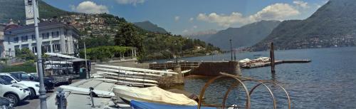 a marina with boats in the water next to a mountain at Volta Como Lake apartament in Brunate