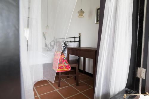 a room with a desk and a chair with a bag at The Marian Boutique Lodging House in Kuching