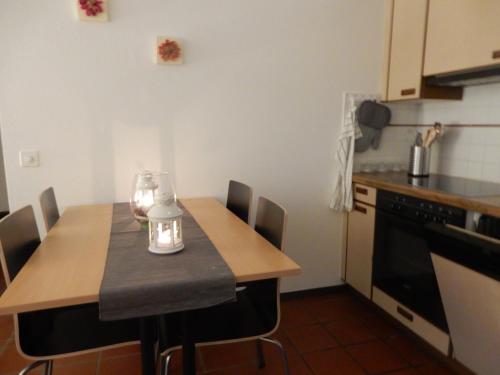 a kitchen with a wooden table with chairs and a stove at Cà Dela in Moghegno