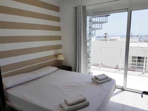 um quarto com uma cama e uma grande janela em Duplex Apartments Nirvana em Callao Salvaje