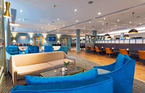 a hotel lobby with blue furniture and a bar at CityNorth Hotel & Conference Centre in Gormanston