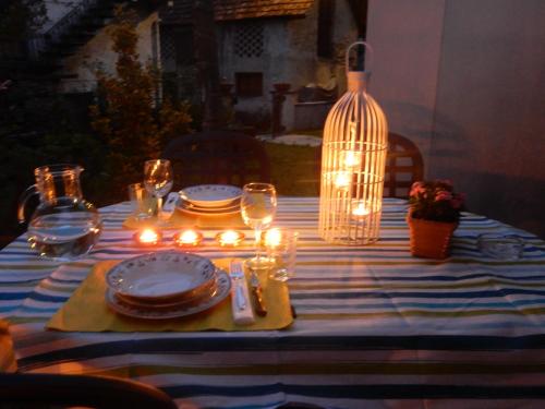 a dinner table with candles and plates and a lamp at Cà Dela in Moghegno