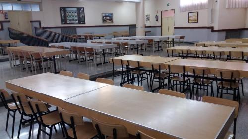 an empty classroom with rows of tables and chairs at Centro San Viator in Valladolid
