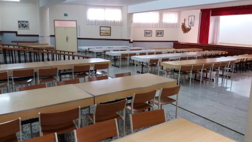 an empty classroom with rows of tables and chairs at Centro San Viator in Valladolid