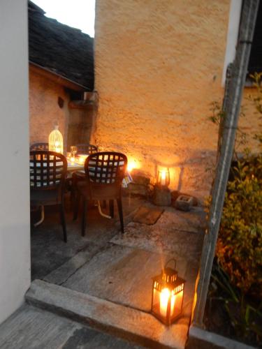 a patio with a table and chairs and lights at Cà Dela in Moghegno