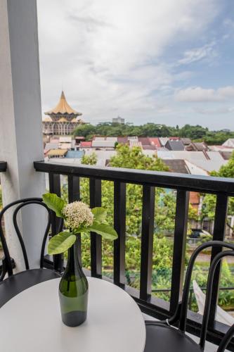a vase with flowers sitting on a table on a balcony at The Marian Boutique Lodging House in Kuching