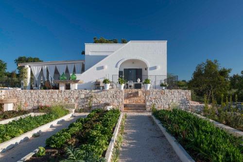 a house with a stone wall and a garden at Tenuta del Lauro in Locorotondo