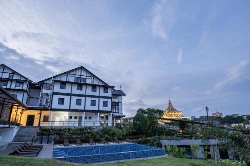 a large white house with a swimming pool in front of it at The Marian Boutique Lodging House in Kuching