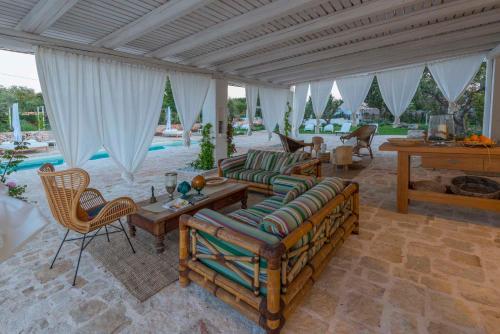 a living room with couches and a table and a pool at Tenuta del Lauro in Locorotondo