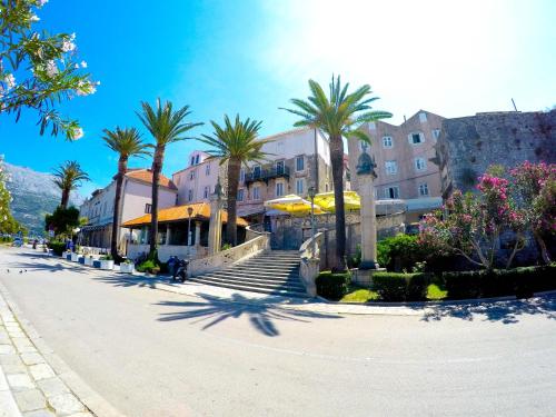 eine Straße mit Palmen und Gebäuden in einer Stadt in der Unterkunft Accommodation Old Town Vitaic in Korčula