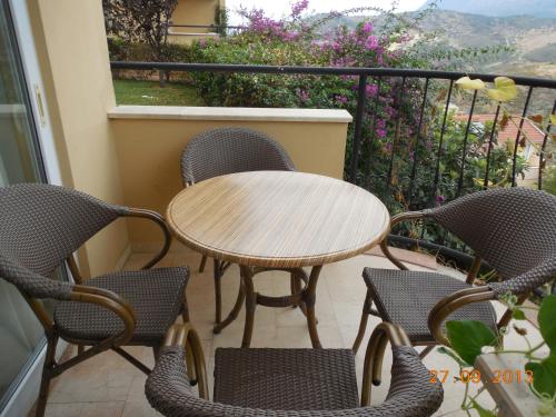 a wooden table and chairs on a balcony at Anastasia Apartments in Kargicak