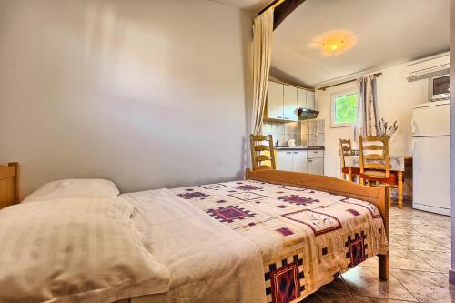 a bedroom with a bed and a kitchen at Apartments & Bungalows Ivanović in Kaštela