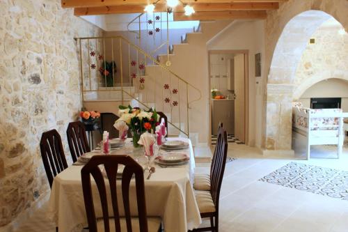 a dining room with a table with chairs and flowers on it at Ioanna House in Gonia