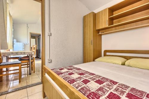 a small bedroom with a bed and a table at Apartments & Bungalows Ivanović in Kaštela