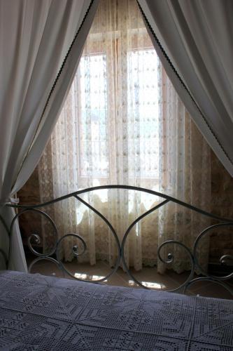 a bedroom with a bed and a window with curtains at Ioanna House in Gonia