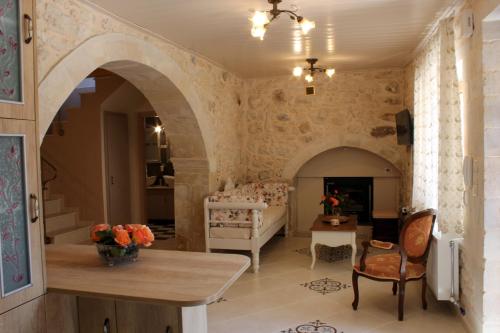 a living room with stone walls and a table and chairs at Ioanna House in Gonia