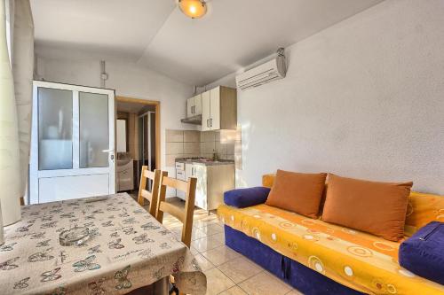a living room with a couch and a table and a kitchen at Apartments & Bungalows Ivanović in Kaštela