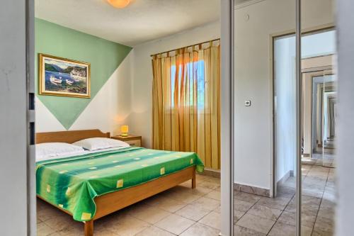 a bedroom with a bed and a glass door at Apartments & Bungalows Ivanović in Kaštela
