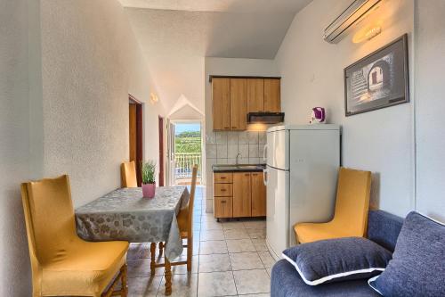 a kitchen and dining room with a table and a refrigerator at Apartments & Bungalows Ivanović in Kaštela