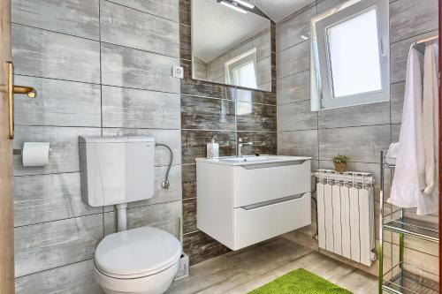 a bathroom with a toilet and a sink at Apartments & Bungalows Ivanović in Kaštela