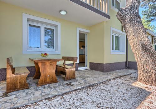 a wooden table and bench in front of a house at Apartments & Bungalows Ivanović in Kaštela