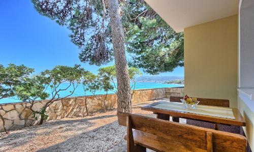 a dining table with a view of the ocean at Apartments & Bungalows Ivanović in Kaštela