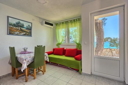 a living room with a green couch and a table at Apartments & Bungalows Ivanović in Kaštela
