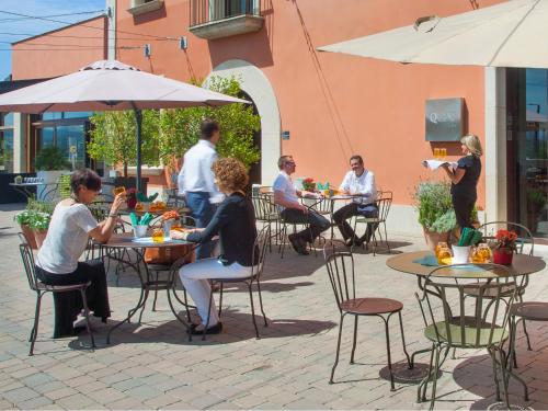 a group of people sitting at tables in a patio at Qgat Restaurant Events & Hotel in Sant Cugat del Vallès