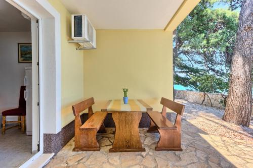 a wooden table with two chairs and a table at Apartments & Bungalows Ivanović in Kaštela