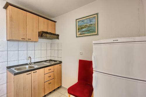 a small kitchen with a sink and a refrigerator at Apartments & Bungalows Ivanović in Kaštela