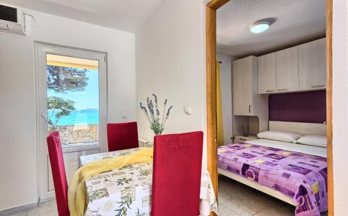 a bedroom with a bed and a table and chairs at Apartments & Bungalows Ivanović in Kaštela