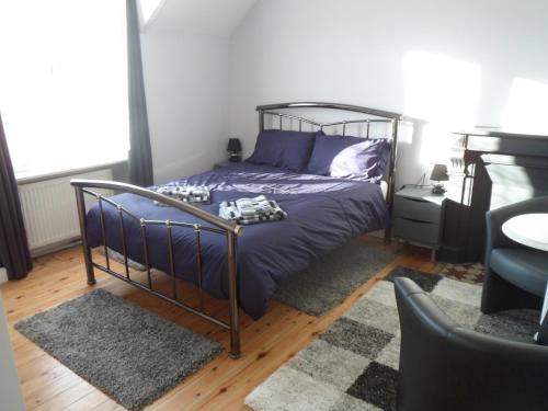 - une chambre avec un lit doté de draps violets et d'un tapis dans l'établissement Riverside Bed and Breakfast, à Huelgoat