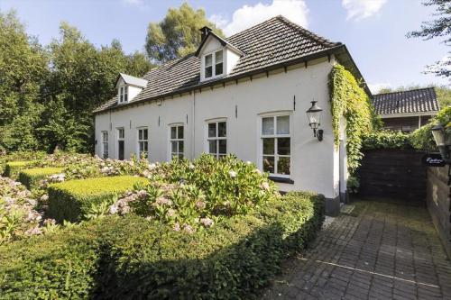 een wit huis met een tuin ervoor bij B&B Het Wellnest in Hulshorst