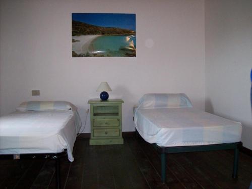 スティンティーノにあるVilla Giglioのベッドルーム1室(ベッド2台付)、壁に絵が描かれたナイトスタンドが備わります。