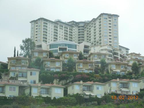 a group of houses in front of a large building at Anastasia Apartments in Kargicak