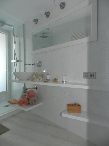 a white bathroom with a sink and a mirror at Cap sa Sal Lofts in Begur