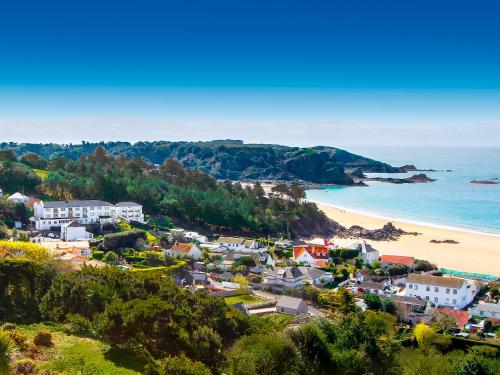 a coastal town with a beach and the ocean at Biarritz Hotel in St Brelade