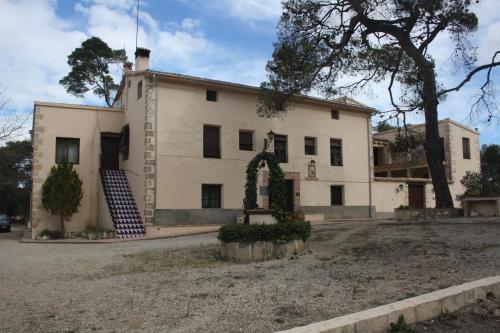a large white house with an arch in front of it at Masía La Safranera in Alcoy