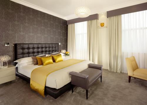 a large bedroom with a large bed with yellow pillows at Taj 51 Buckingham Gate Suites and Residences in London
