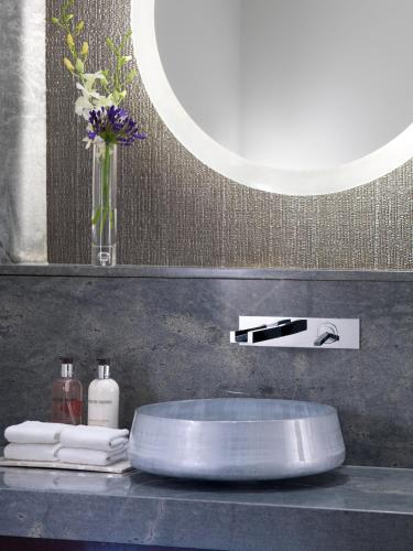 a bathroom counter with a sink and a mirror at Taj 51 Buckingham Gate Suites and Residences in London