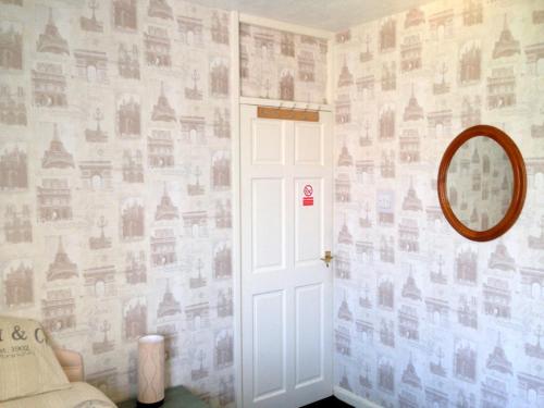 um quarto com uma porta e uma parede coberta de fotografias em Liverpool Airport Rooms em Speke