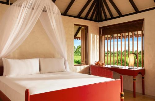 a bedroom with a bed and a window at Jetwing Kaduruketha in Wellawaya