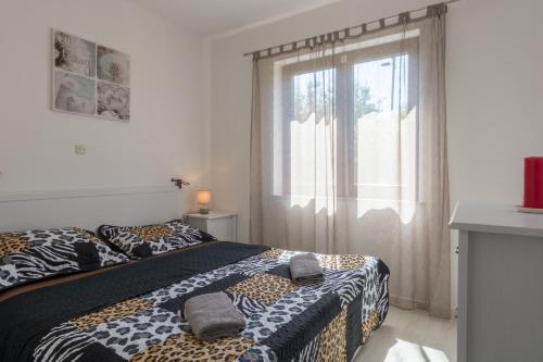 a bedroom with two beds and a window at Apartments Sun in Zadar