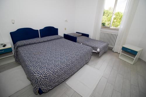 1 dormitorio con 2 camas y ventana en Hotel Cristallo en Riolo Terme