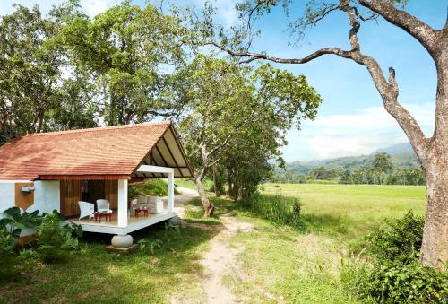a small house in the middle of a field at Jetwing Kaduruketha in Wellawaya