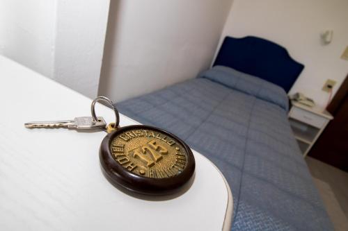 a key chain on a table next to a bed at Hotel Cristallo in Riolo Terme